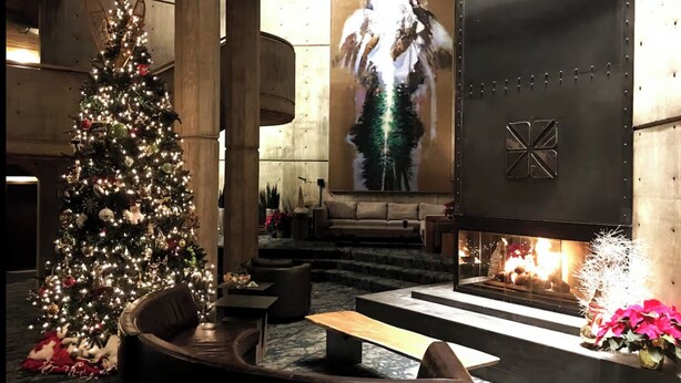 A cozy lobby with a large Christmas tree, comfortable seating, a fireplace, and a large painting on the wall. - Ski-in/ski-out unit 1027 for 4 people @Snowbird for New Year's week, 12/27-1/3 (Snowbird)