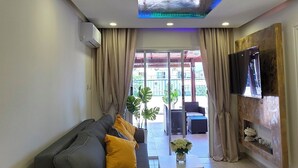 Ein modernes Wohnzimmer mit einer Couch, einem Couchtisch und einem an der Wand befestigten Fernseher.