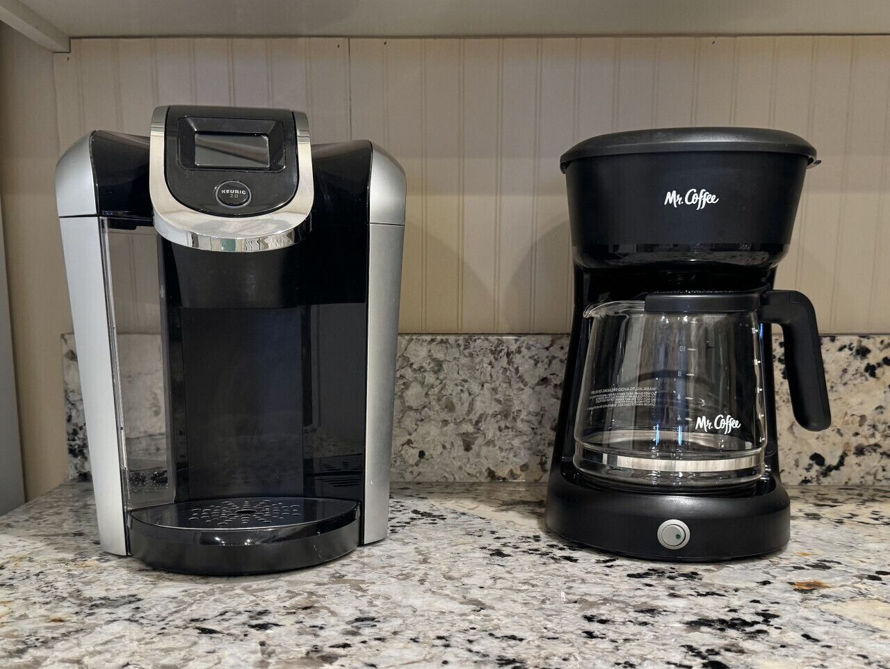 A coffee maker and a glass carafe on a kitchen counter.