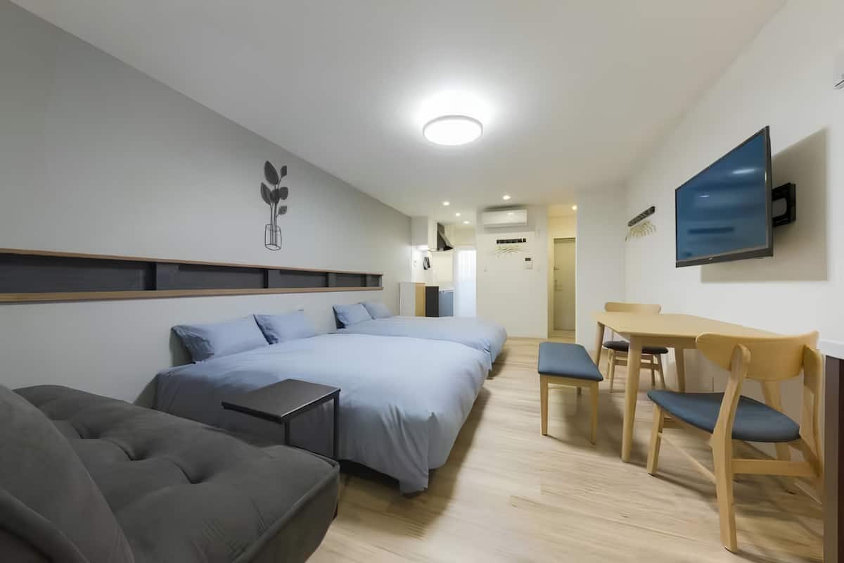 Una camera d'albergo moderna con un letto grande, un divano, una scrivania e una TV.