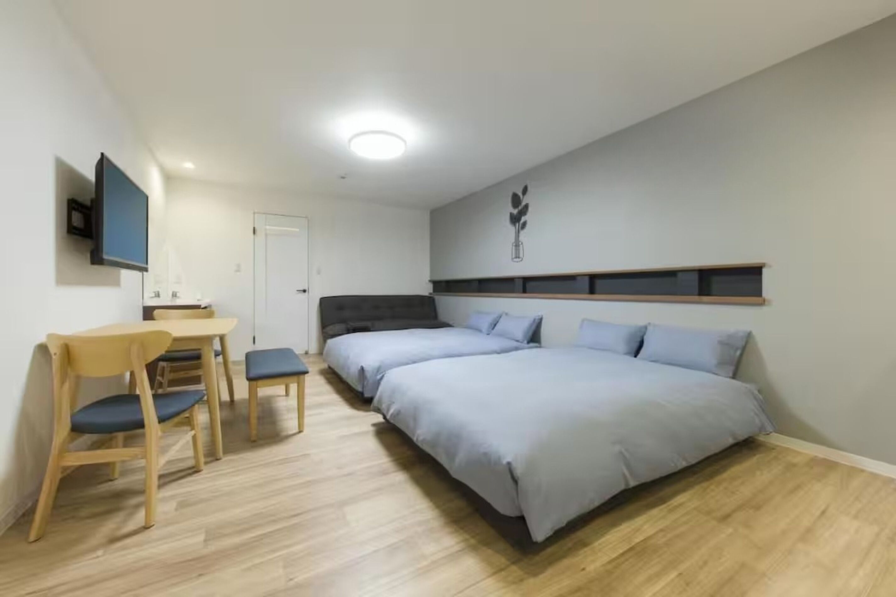 A bedroom with a bed, a desk, and chairs.