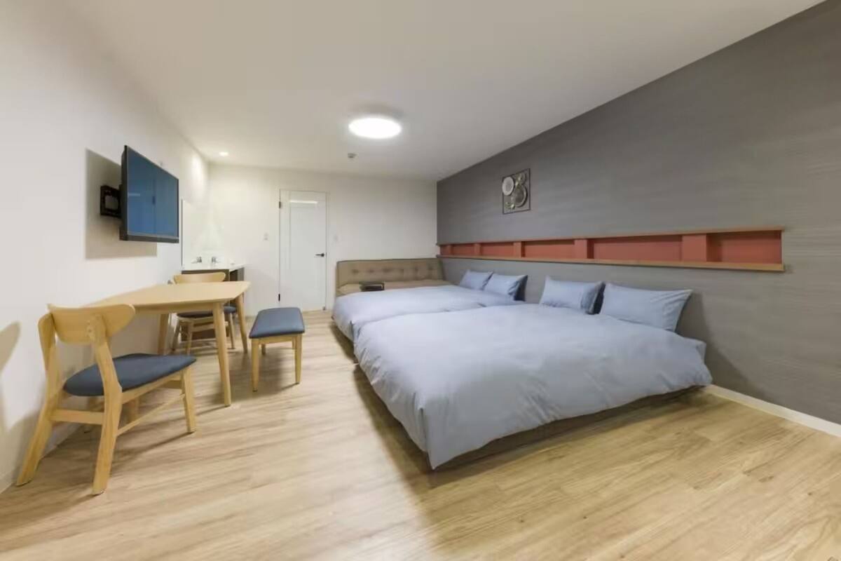 Una camera da letto con un letto, una scrivania e delle sedie.