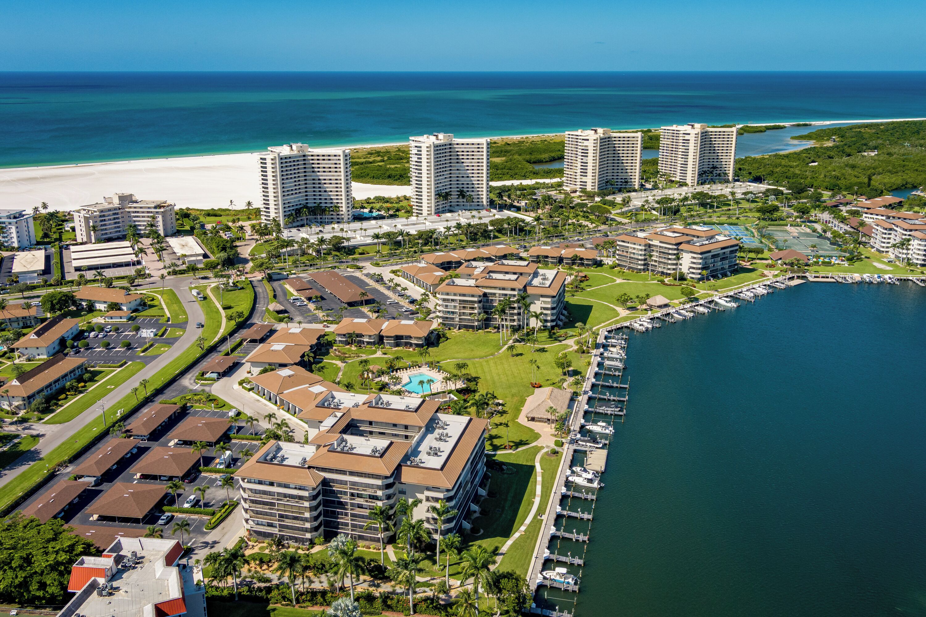 A coastal resort with multiple high-rise buildings, a marina, and a beach.