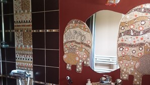 A bathroom with a shower, a sink, and two decorative mirrors. - Room in thatched cottage in the countryside 2 kms from pointe de la torche (Penmarch)