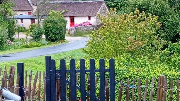 A rural house with a thatched roof, surrounded by lush greenery and a wooden fence. - Room in thatched cottage in the countryside 2 kms from pointe de la torche (Penmarch)