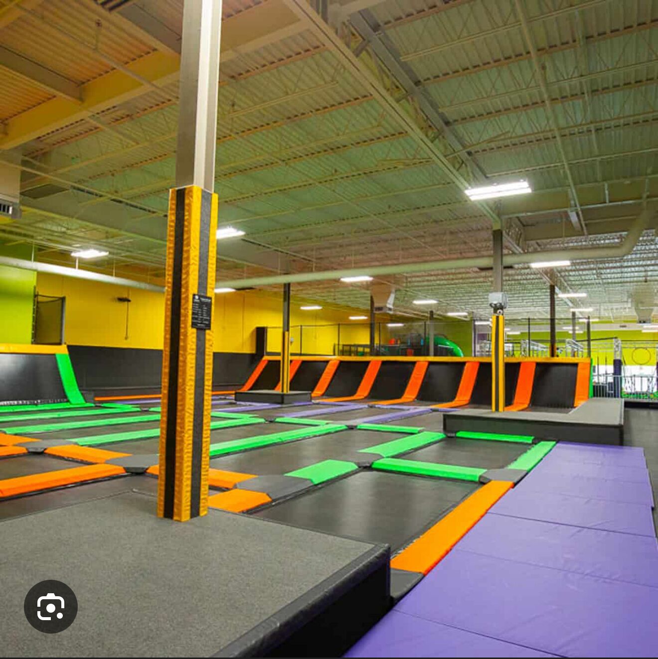 A trampoline park with multiple trampolines and padded safety areas.