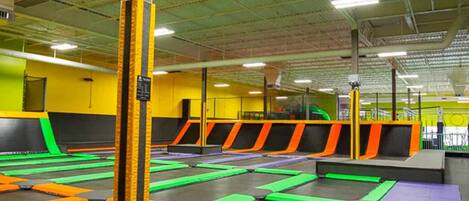 A trampoline park with multiple trampolines and padded safety areas.