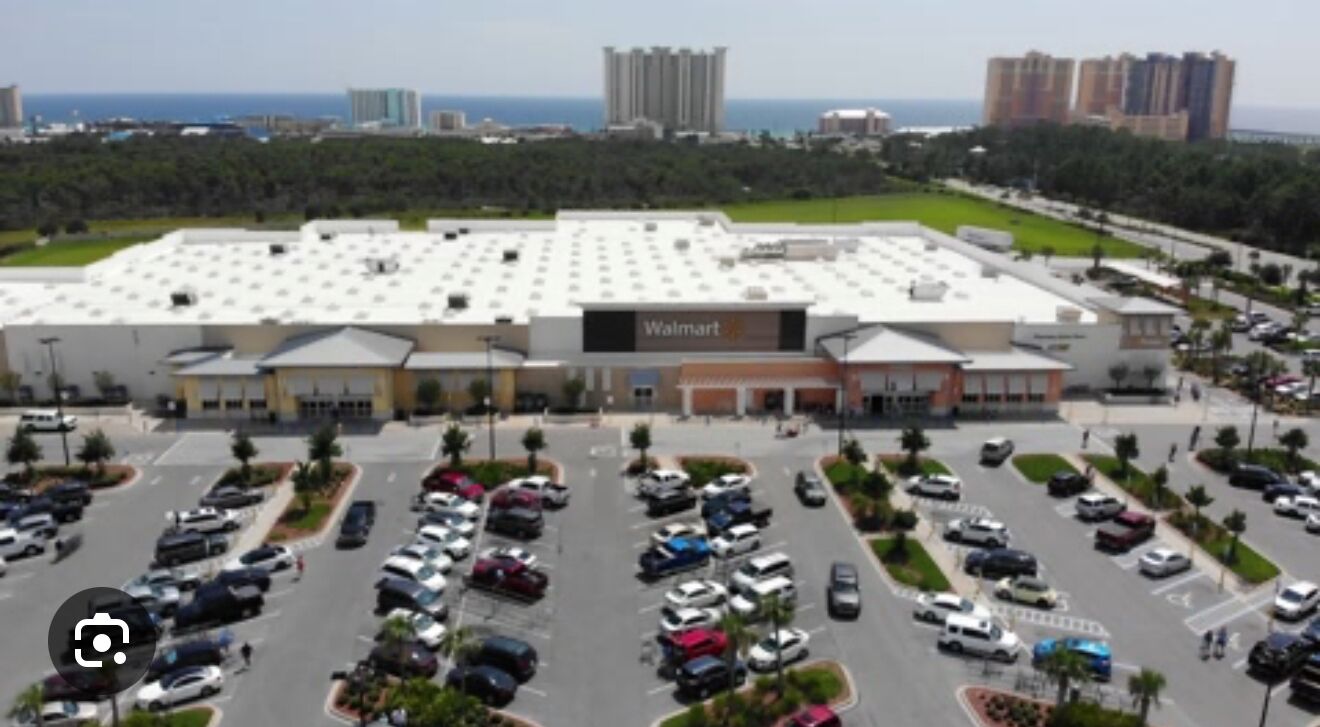 Una tienda Walmart con un estacionamiento amplio y vista al océano.