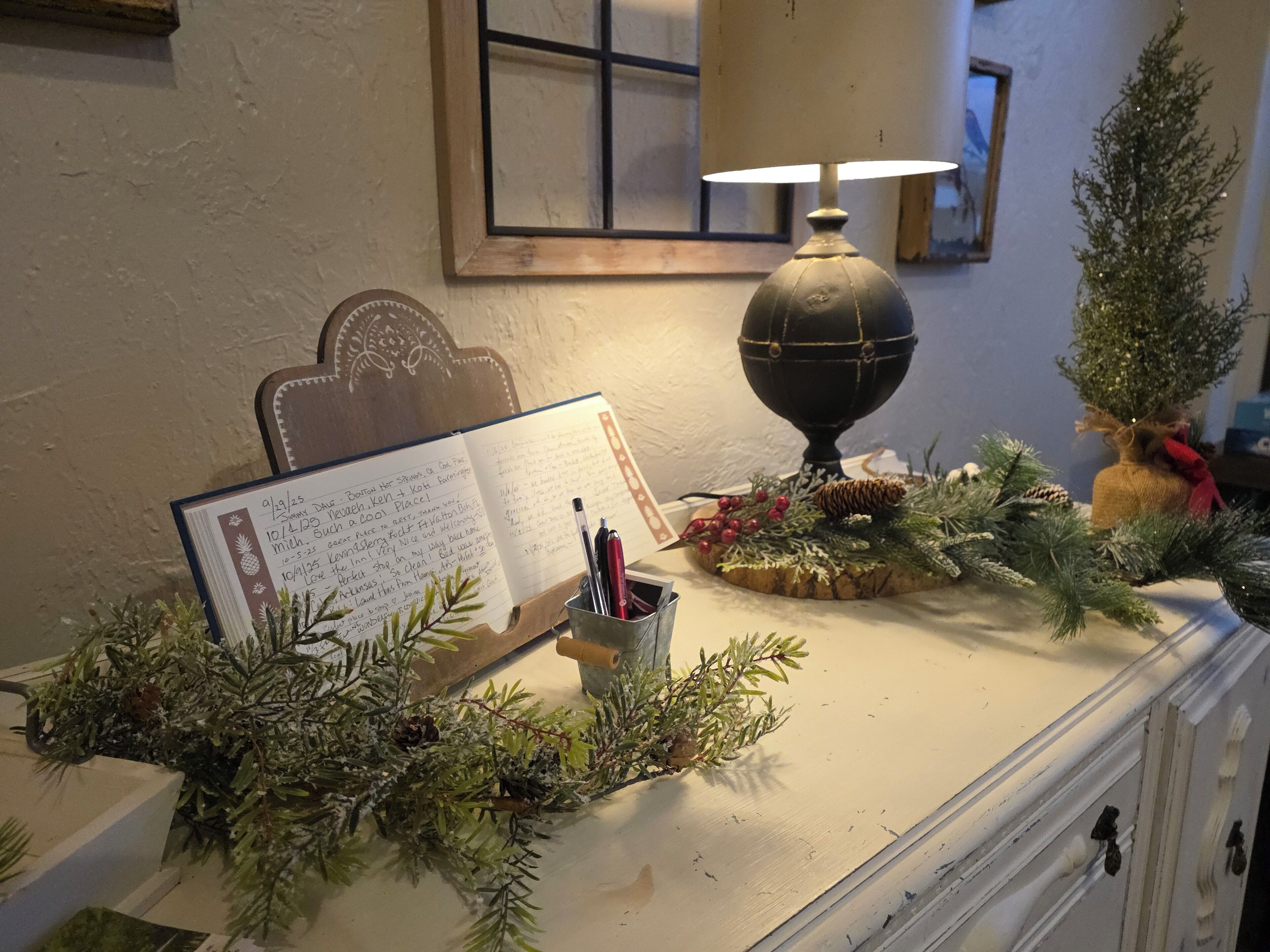 A desk with a notebook, a lamp, and holiday decorations.