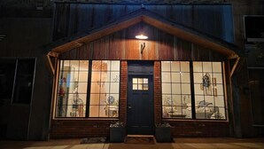 A building with a bird-shaped neon sign above the entrance, large windows, and a wooden facade. - Bluebird Place (Elk City)
