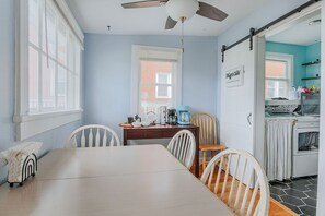 A dining area with a table and chairs, a kitchen with a stove and cabinets, and a ceiling fan. - The Wayne Shire: Sleeps 8 + Downtown Waynesboro (Waynesboro)