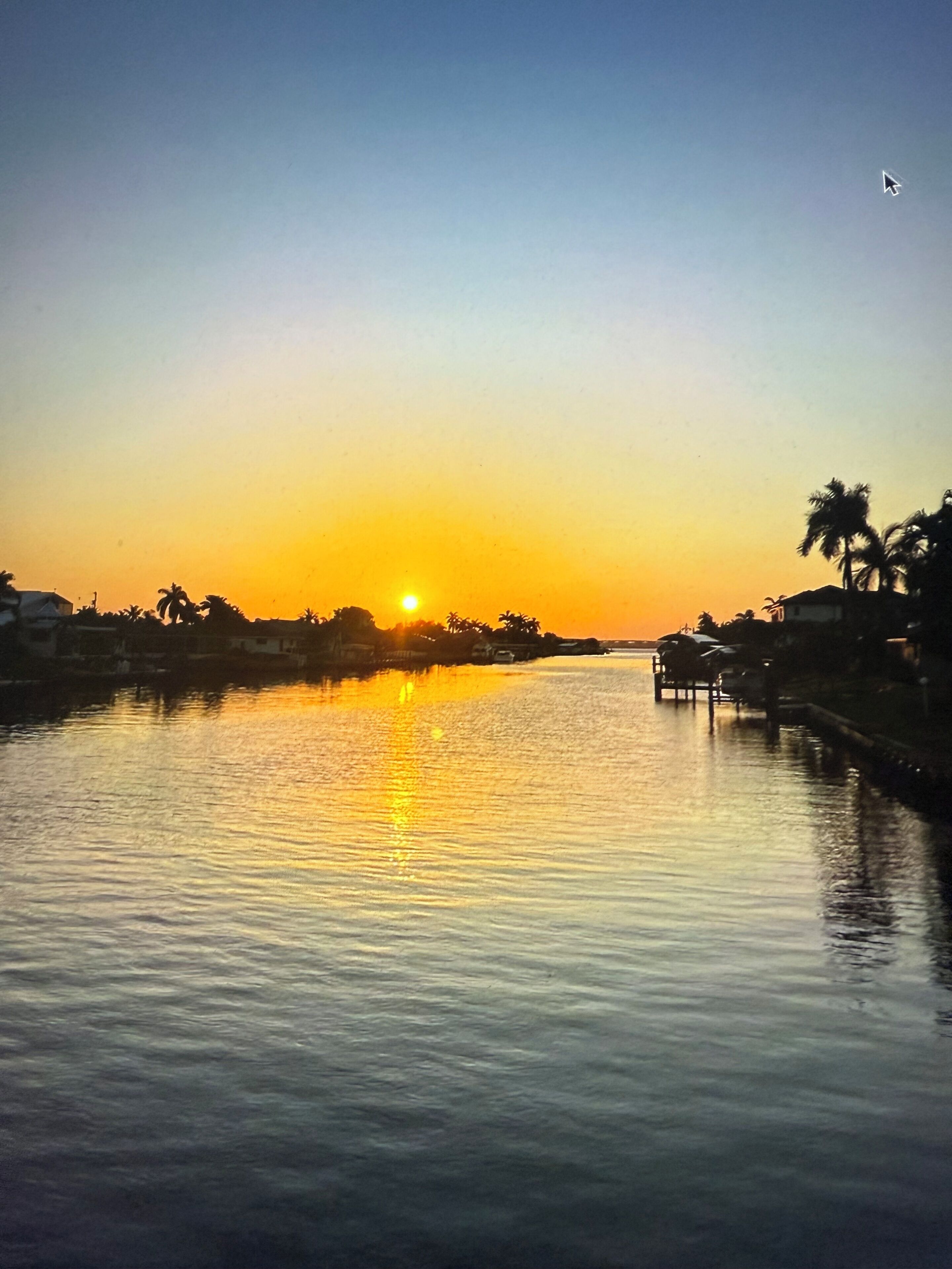 Ein ruhiger Fluss bei Sonnenuntergang mit blauem Himmel.