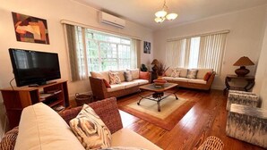 Ein Wohnzimmer mit zwei Sofas, einem Couchtisch, einem Fernseher und einer Lampe.