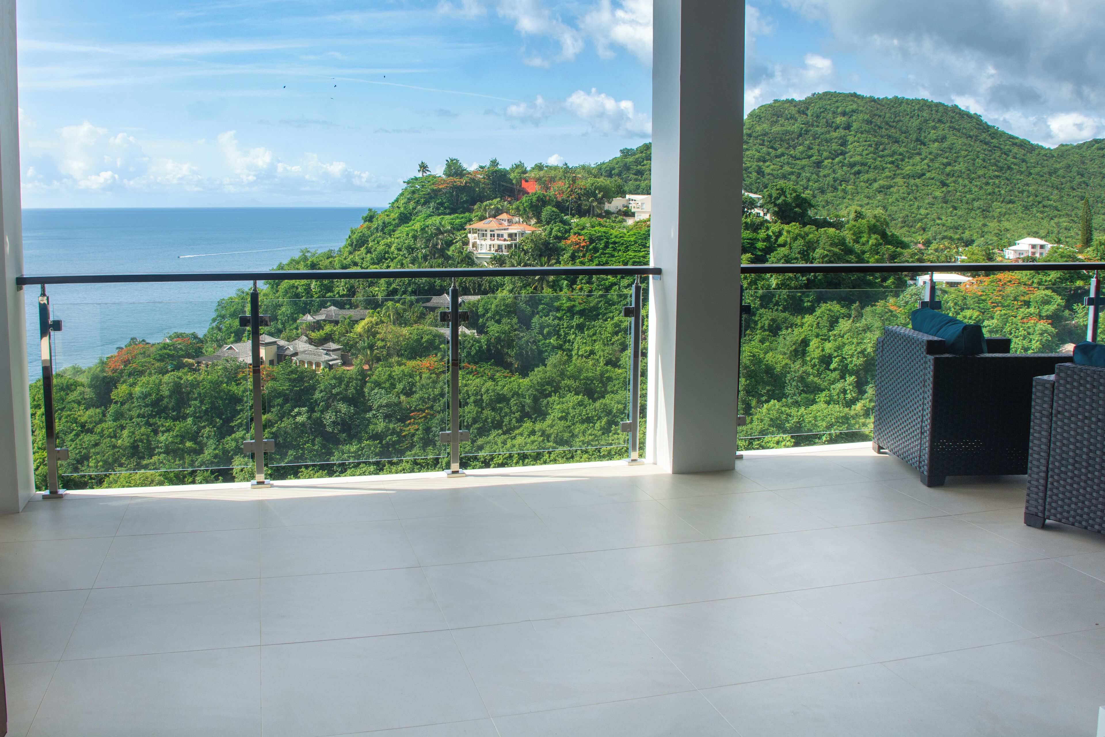 Ein Balkon mit Blick auf eine gebirgige Landschaft und das Meer.