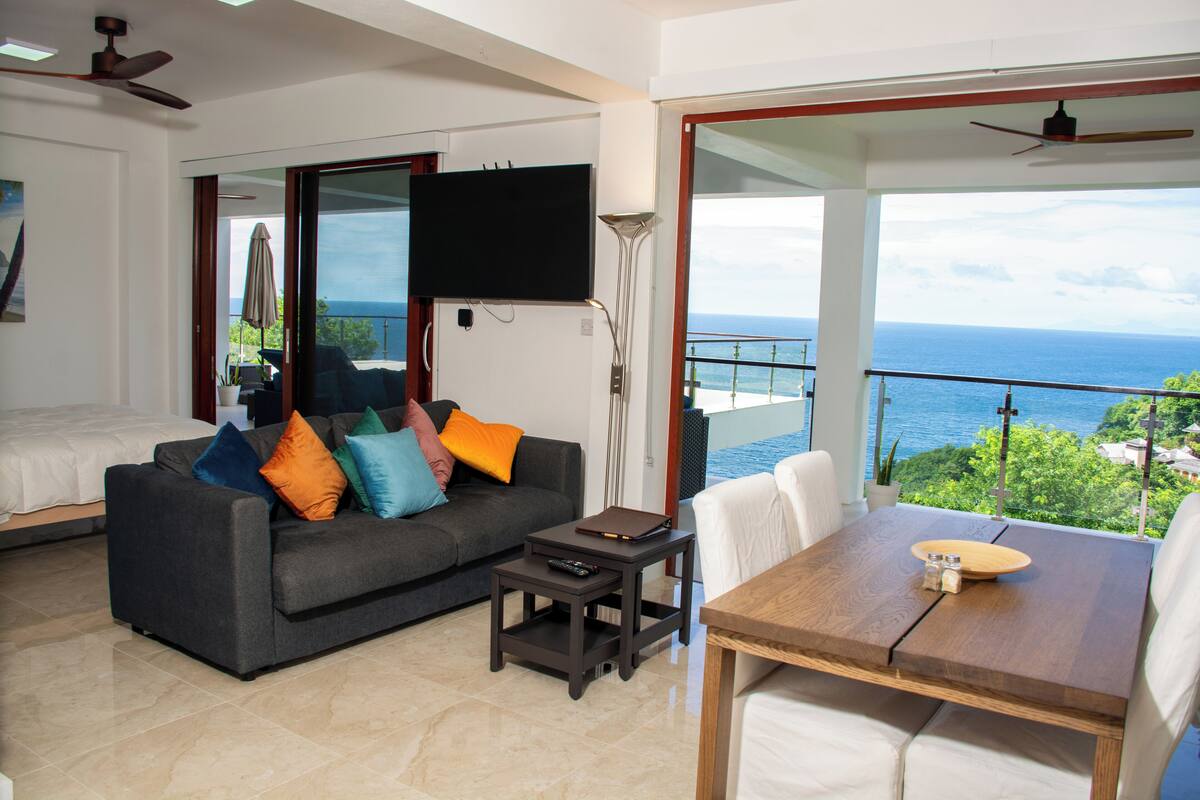 A modern living room with a sofa, a coffee table, and a TV mounted on the wall.