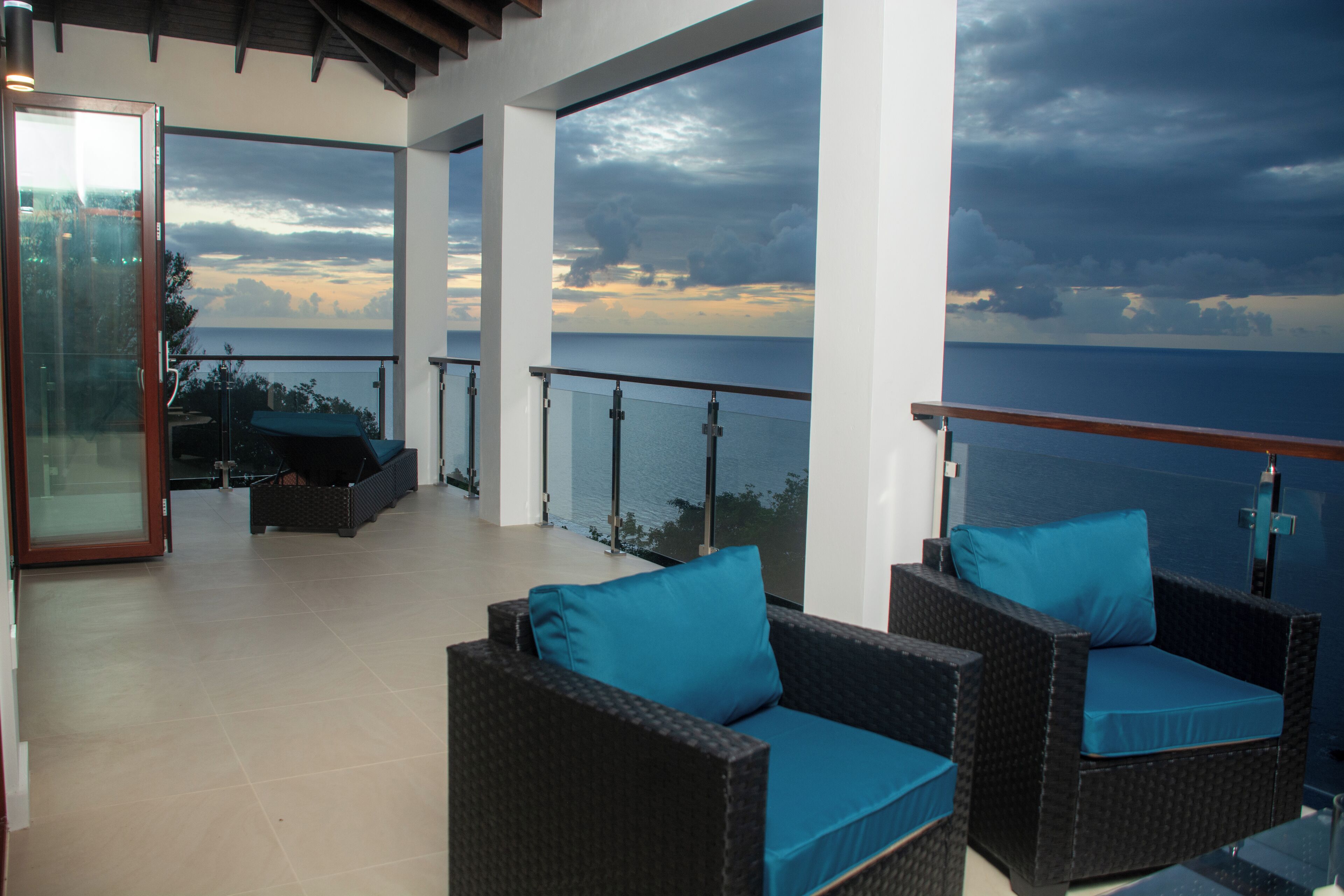 A balcony with wicker furniture and a glass door leading to the interior.