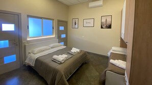 A hotel room with a bed, a window, a wall-mounted air conditioner, and a door with a light strip. - B&B l'angoletto (Trebisacce)