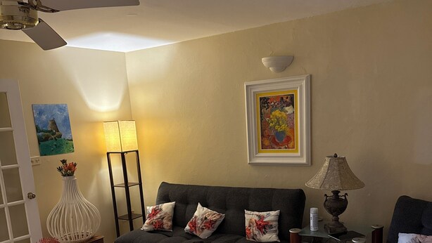 Ein Wohnzimmer mit Sofa, Couchtisch, Lampe und Deckenventilator.