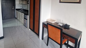 A modern hotel room with a dining area, a kitchen in the background, and a framed artwork on the wall. - A spacious Studio apartment / condo near Clark Airport angeles city pampanga (Angeles)