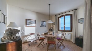 Un coin repas avec une table ronde, des chaises et une sculpture de poisson posée sur un meuble.