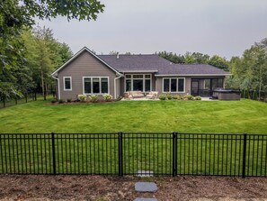A two-story house with a well-maintained lawn, a patio with outdoor furniture, and a hot tub. - SOMETHING FOR EVERYONE,  New 3+ BR, 4 Bath, Ranch, Game Rm, Fenced Yd & Pond (Fennville)