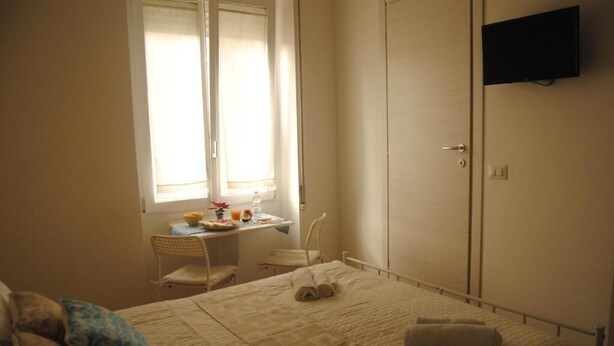 A bedroom with a bed, a desk, a chair, and a wardrobe. - Coro & Bentu  (Alghero)
