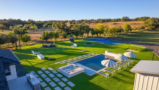 A well-maintained backyard with a swimming pool, lounge chairs, and a hot tub. - Camp Starlight–Luxe Villa w/ Pickleball, Pool, Spa (Dripping Springs)