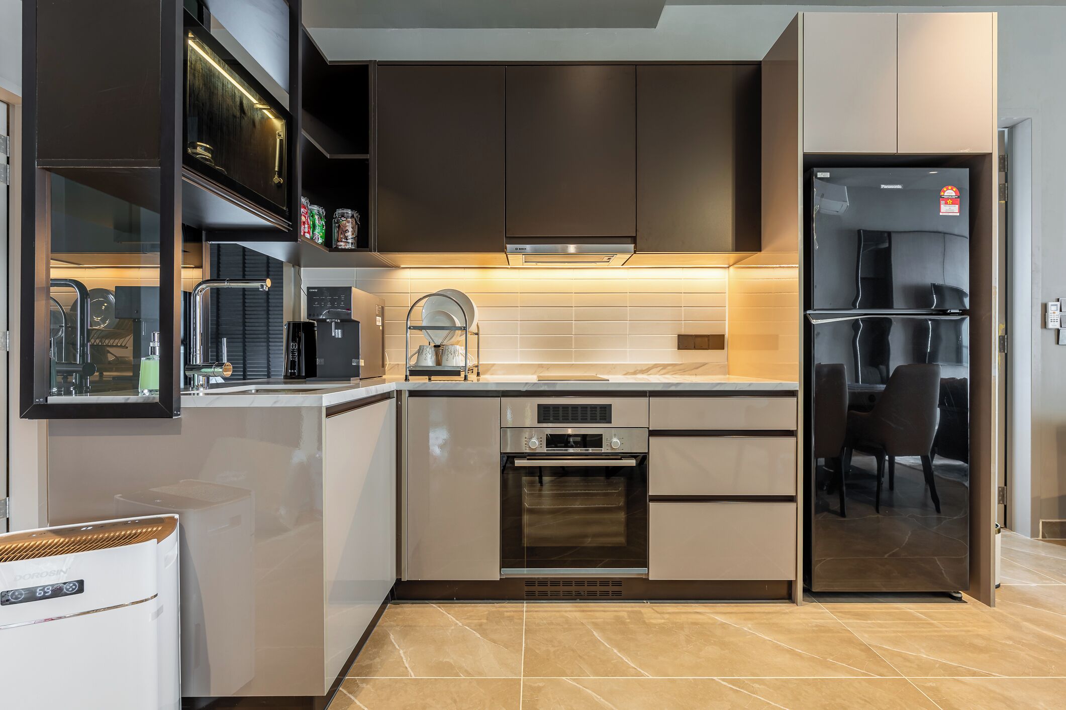 A modern kitchen with built-in appliances, a dishwasher, and a refrigerator.