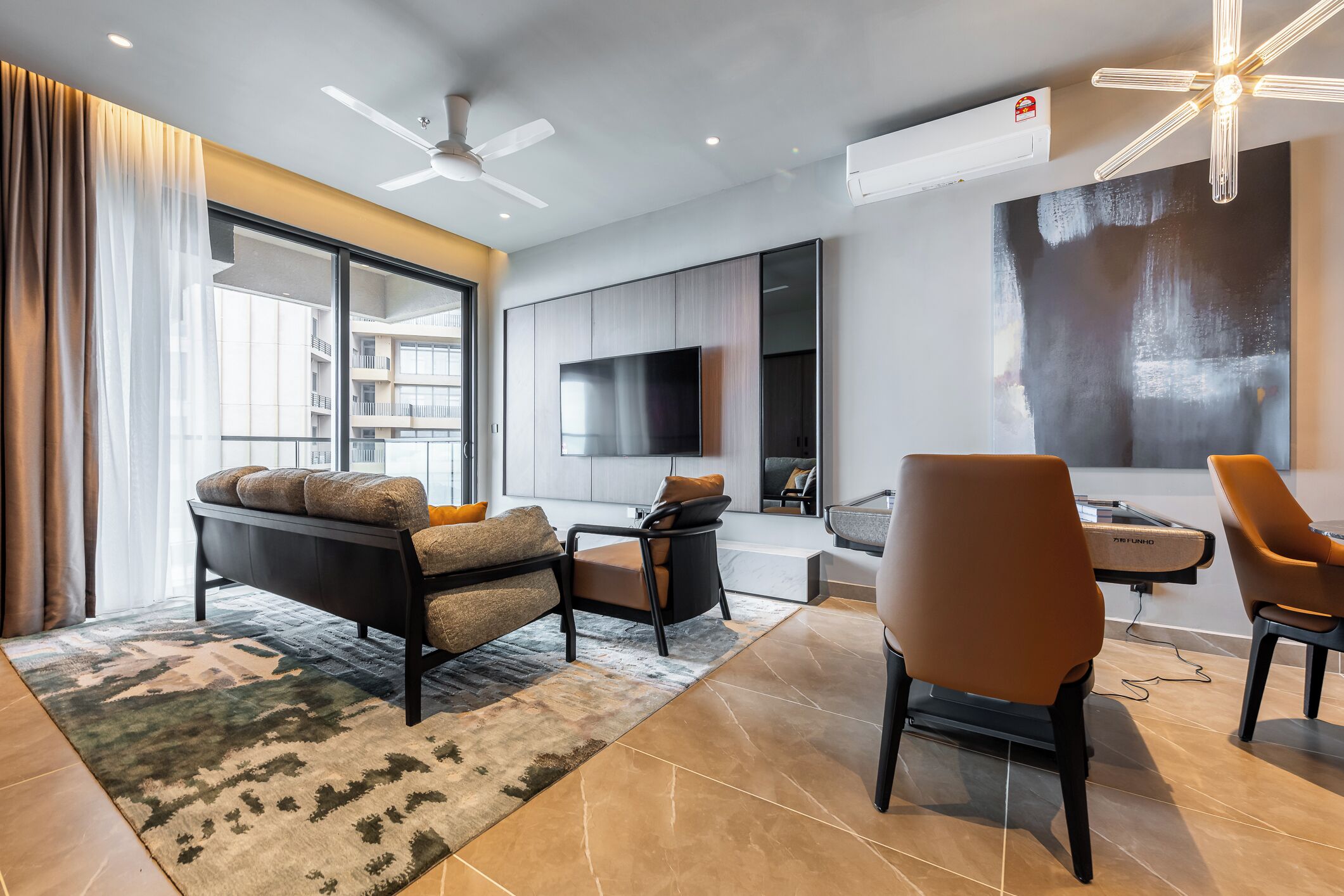 A modern living room with a sofa, chairs, a TV, and a large window.