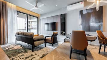 A modern living room with a sofa, chairs, a TV, and a large window.