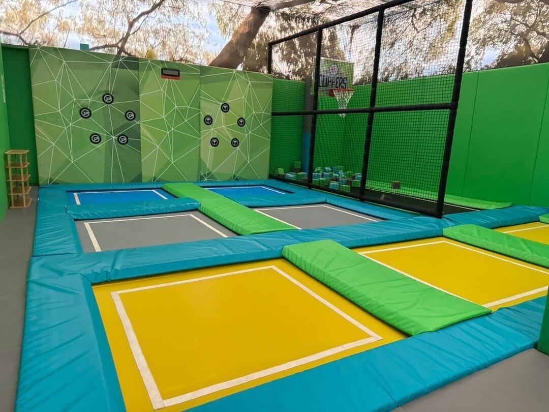 Un área de trampolines con varias trampas y una red de protección.