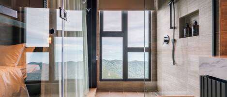 Un baño moderno con un ventanal grande, ducha y bañera.