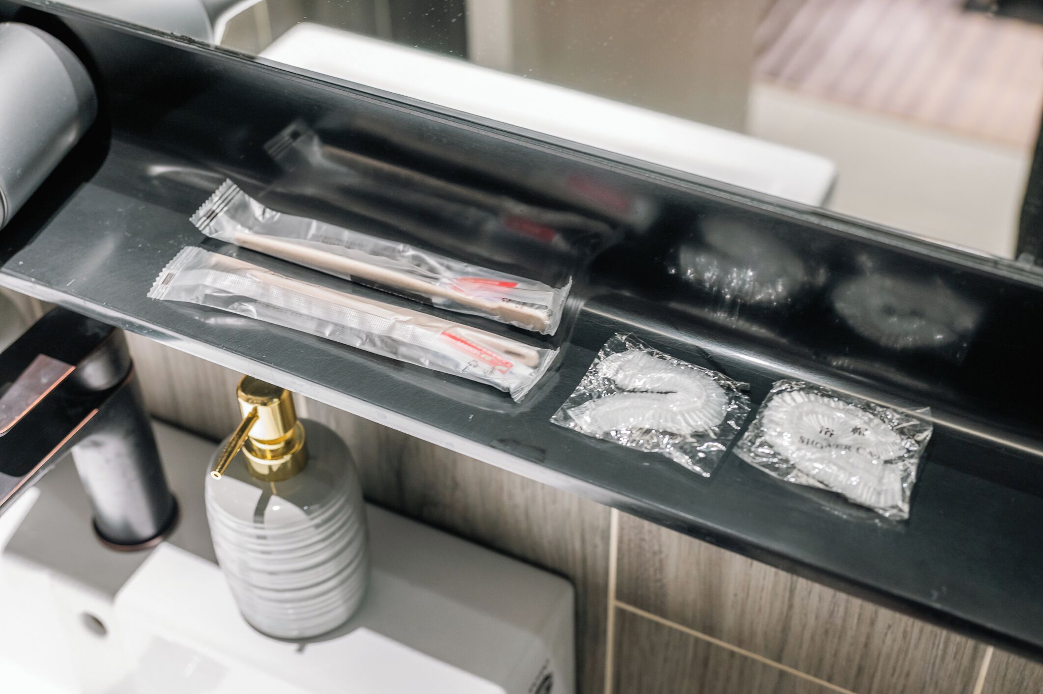 A hotel reception area with a black counter displaying toiletries and a water dispenser.
