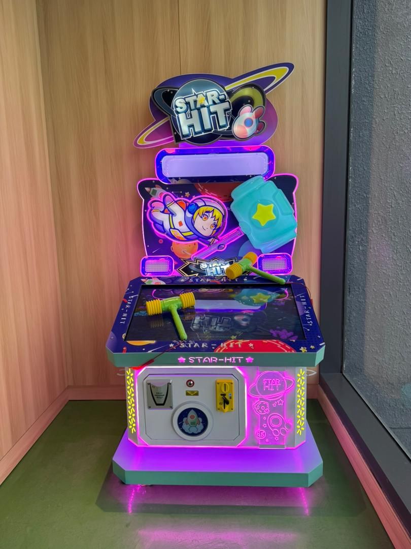 A Star-Hit arcade machine with a colorful design, a joystick, and a screen displaying a character.
