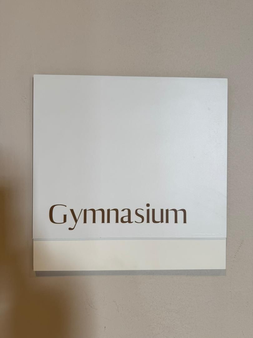 Un letrero con la palabra 'Gymnasium' sobre un fondo blanco.