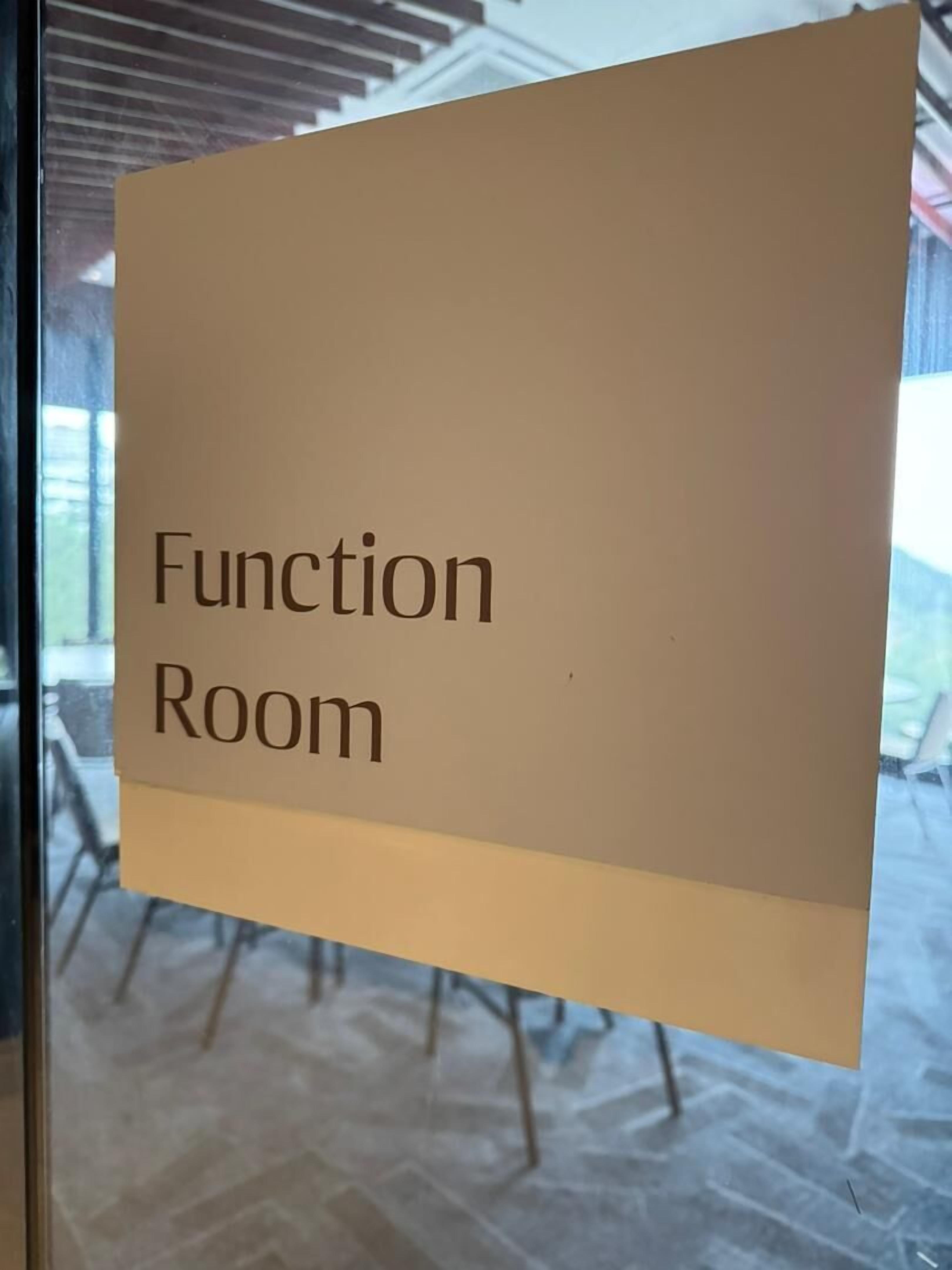 A sign that reads "Function Room" on a window.
