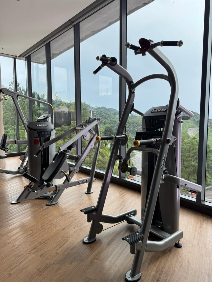 A gym with exercise equipment and large windows offering a view of a mountainous landscape.
