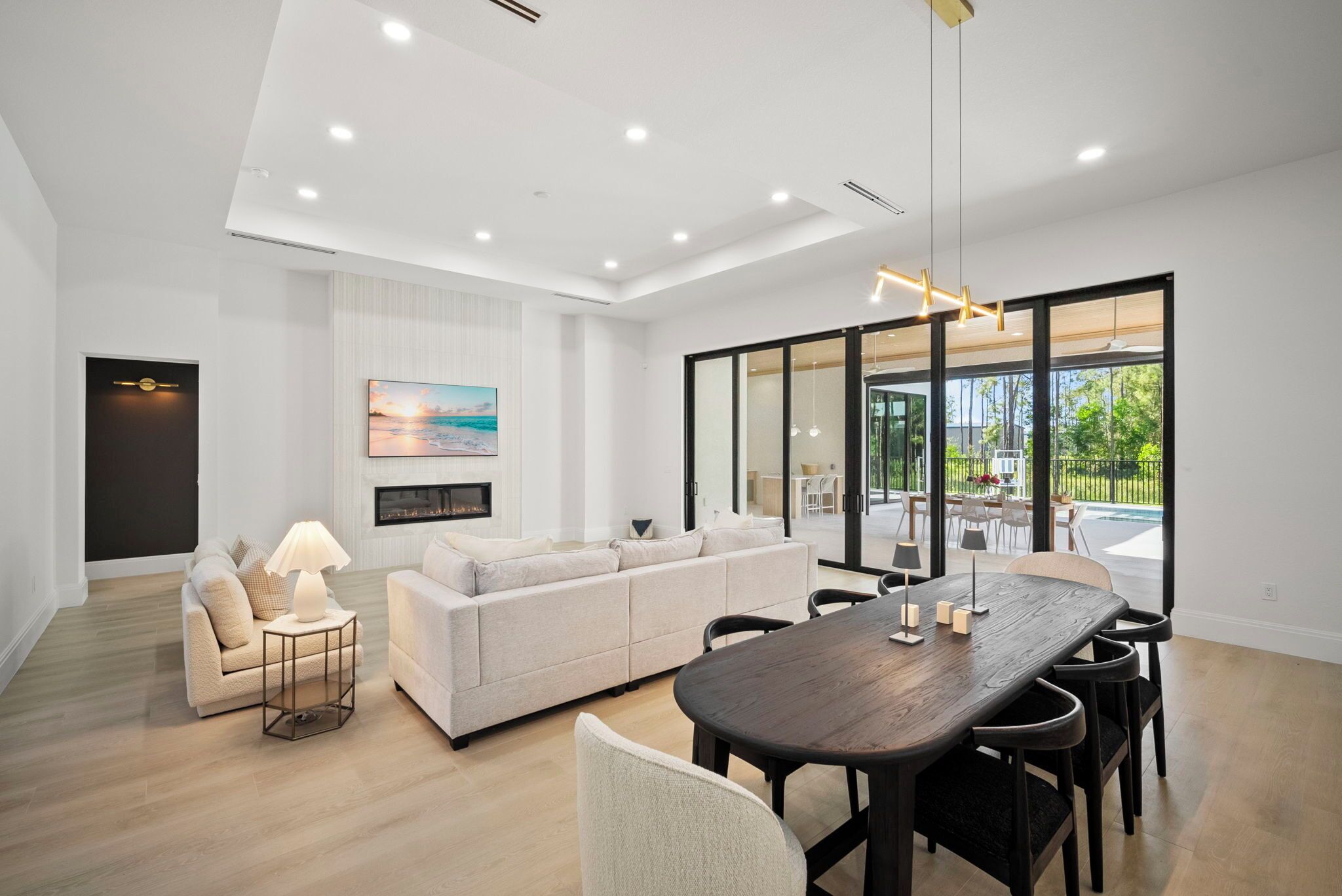 A spacious living area with a large sofa, a dining table, and a fireplace.
