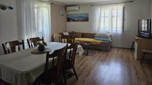 Un espacio habitable compacto con una mesa de comedor, sillas, un sofá y una televisión.