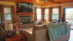 Una sala de estar acogedora con chimenea, asientos cómodos y televisor.