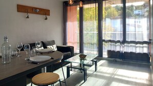 A modern kitchen with a dining area, large windows, and a view of the outside. - Comfortable 3-bedroom T4 apartment (Mourenx)