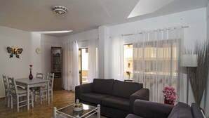 A living room with a grey sofa, a coffee table, and a dining area with a table and chairs. - Casa Pimenta near the beach, Iberlagos Resort (Lagos)