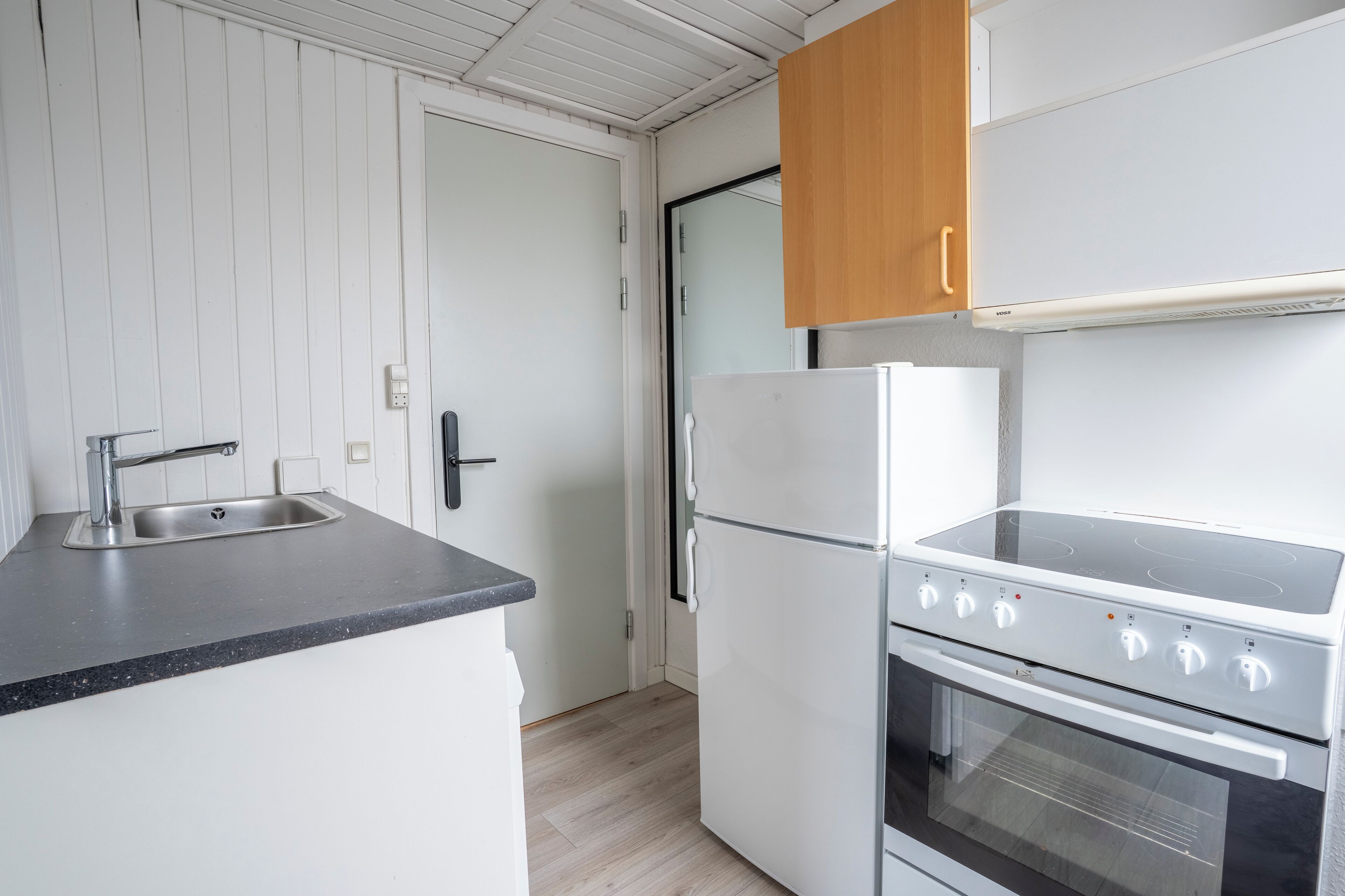 A compact kitchen with a sink, a refrigerator, and a stove.