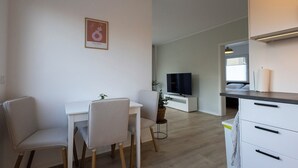 A modern living space with a dining area, a TV, and a kitchenette. - Stylish & central vacation apartment in Oranienburg (Oranienburg)