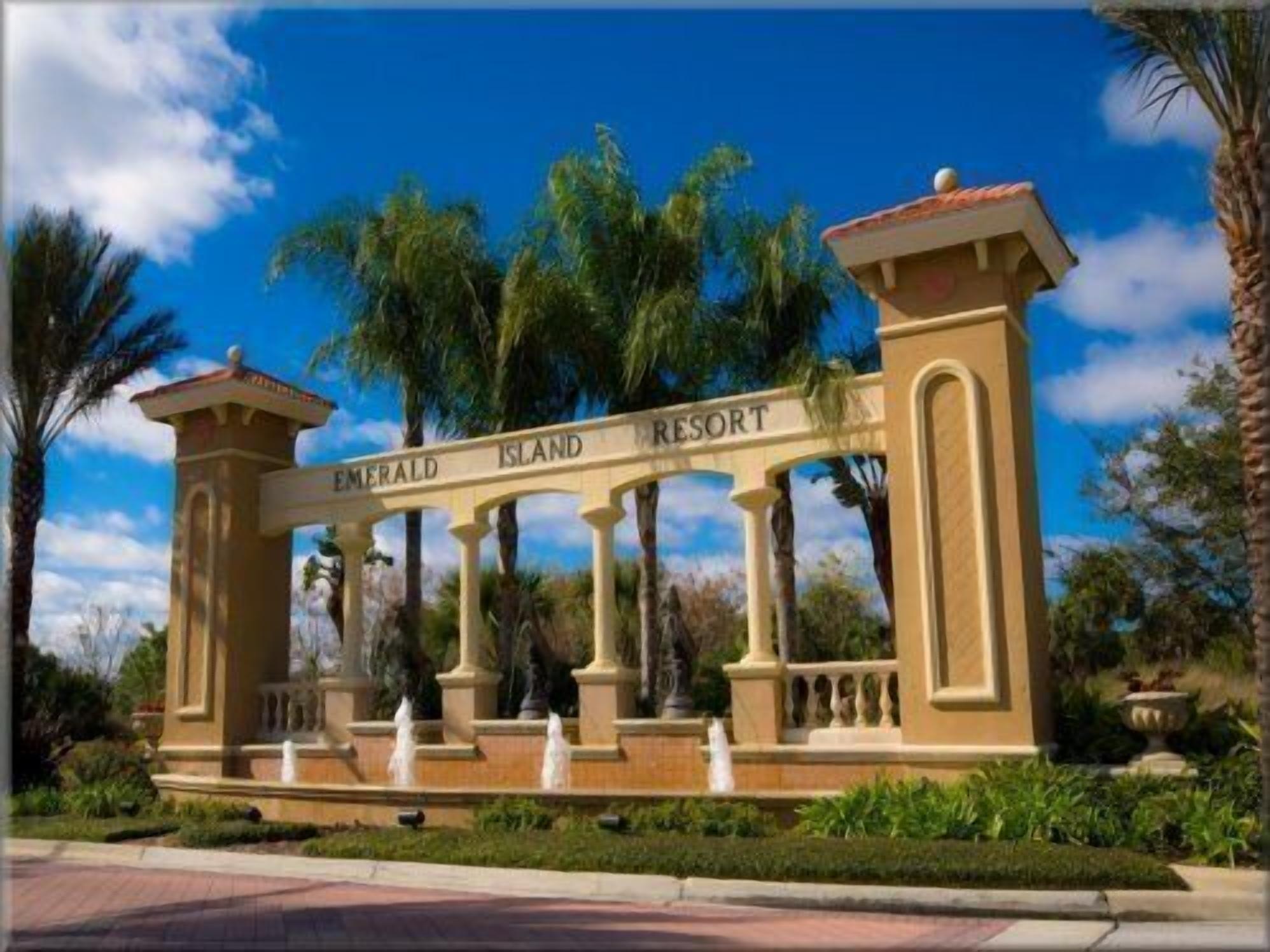 A resort entrance with a sign reading "Emerald Island Resort" and a fountain in the foreground.
