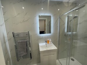 Een douche, handdoeken, zeep, toiletpapier