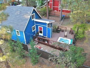 Ein blaues, zweistöckiges Haus mit Terrasse und Whirlpool.