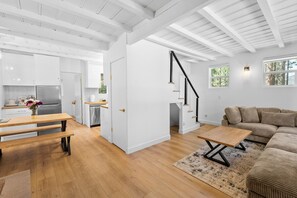 Ein modernes Interieur mit einem Holztisch, einer Couch und einer Treppe.
