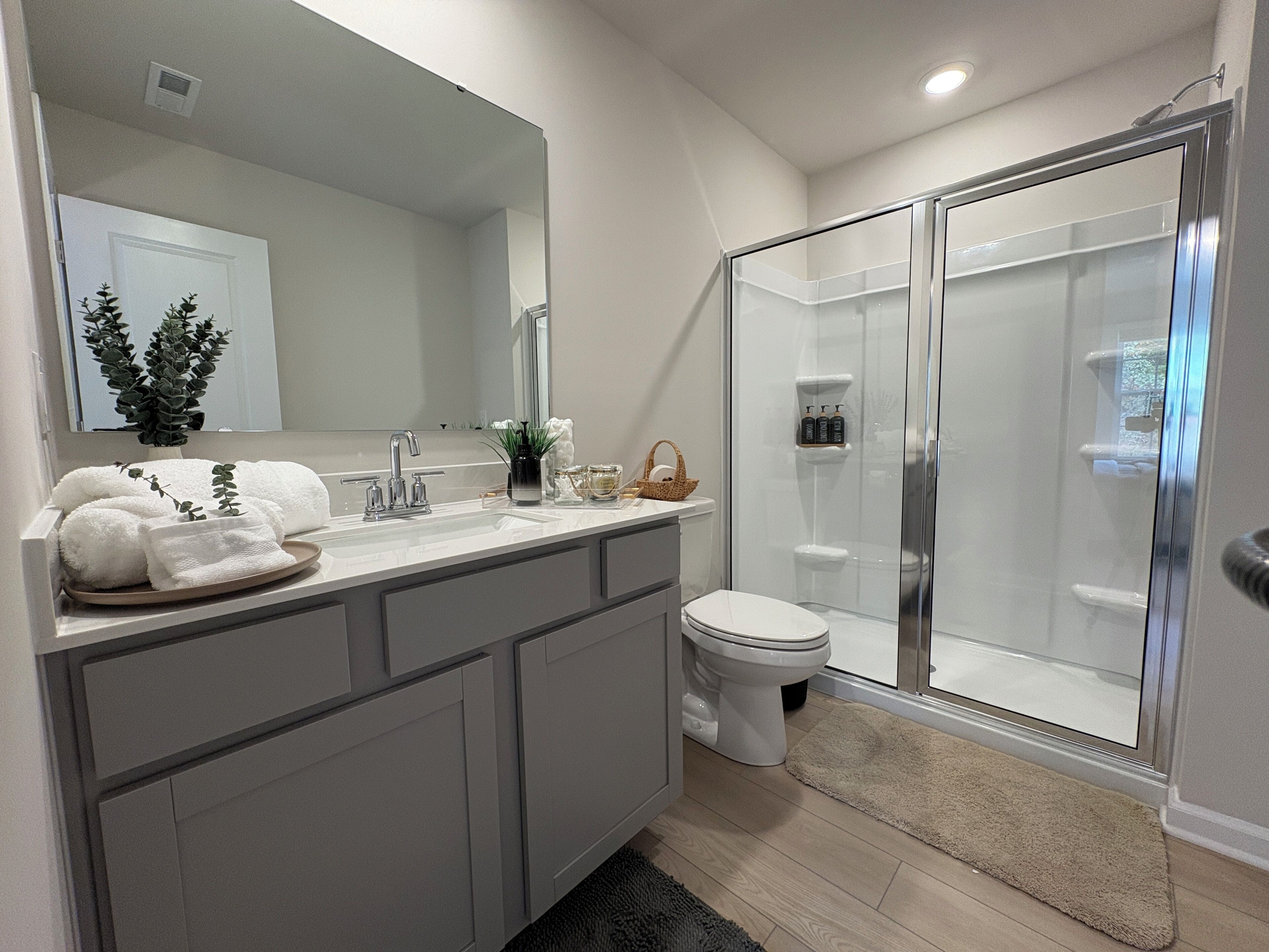 A modern bathroom with a shower, toilet, and vanity.
