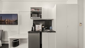 Una kitchenette compacta equipada con microondas, pileta y refrigerador.